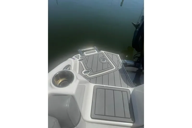 Slide: The Image of 2021 NauticStar 243 DC boat deck with cup holder and swim platform ladder. - 18