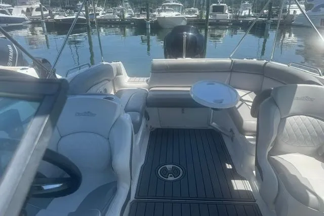 Slide: The Image of 2021 NauticStar 243 DC boat interior with seating and table, docked at marina. - 17