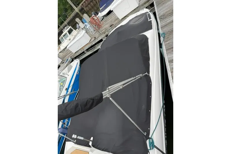 Slide: The Image of 2021 NauticStar 243 DC boat with black cover docked at marina. - 24
