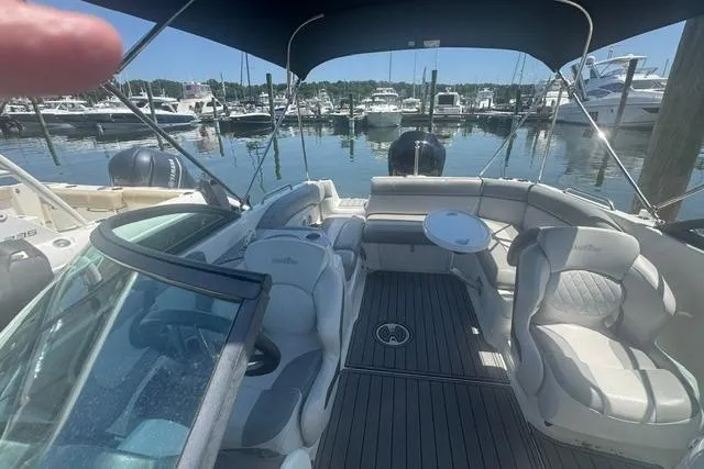 Slide: The Image of 2021 NauticStar 243 DC boat interior with seating and table, docked at marina. - 13