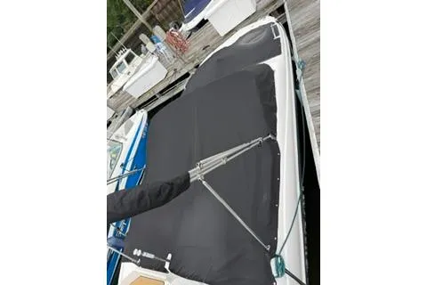 Slide: The Image of 2021 NauticStar 243 DC boat with black cover docked at marina. - 25