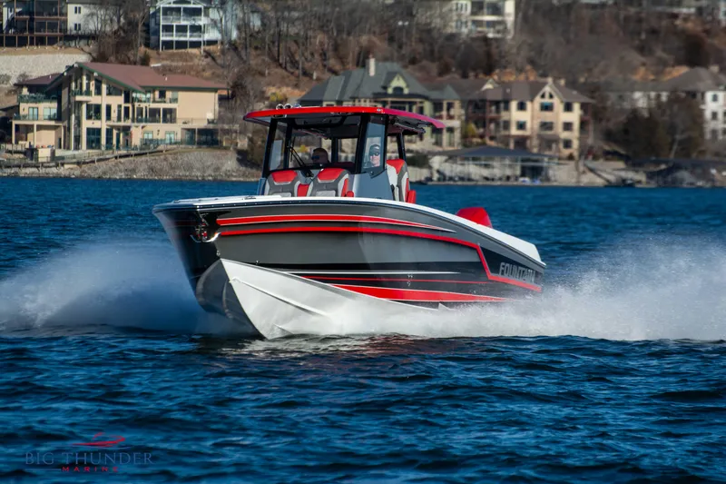 Slide: The Image of A 2023 Fountain 32 NX boat speeds across the water, featuring red and gray accents. - 10