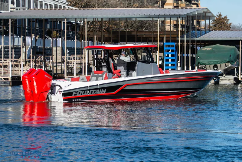Slide: The Image of 2023 Fountain 32 NX on the water with red accents and twin outboard engines. - 8