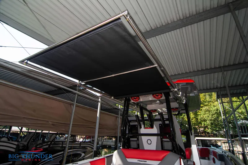 Slide: The Image of A 2023 Fountain 32 NX boat with a modern sunshade in a marina. - 27