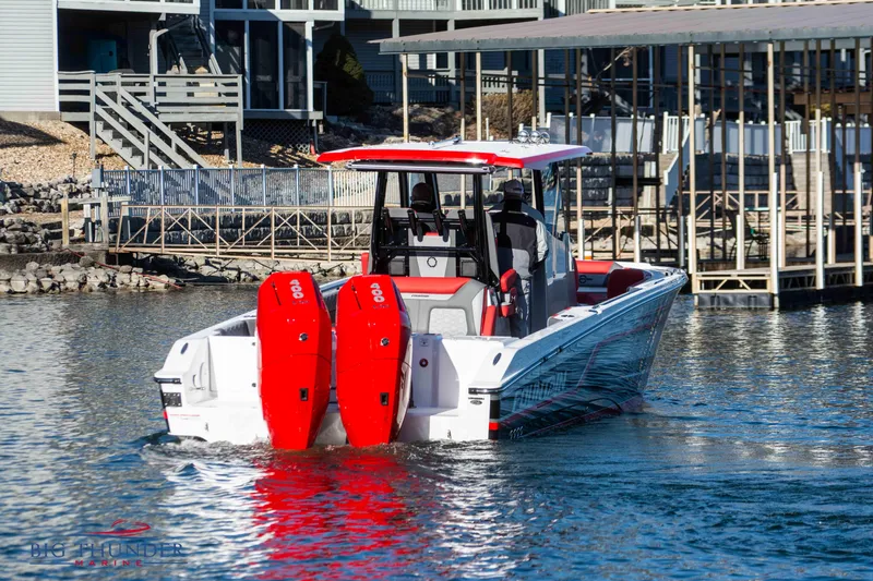 Slide: The Image of A 2023 Fountain 32 NX boat with two red outboard engines cruising on a lake. - 7