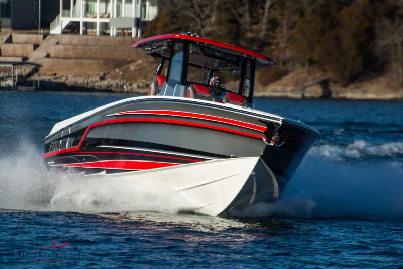 Slide: The Image of A 2023 Fountain 32 NX boat speeds across the water, featuring a striking red and gray design. - 5