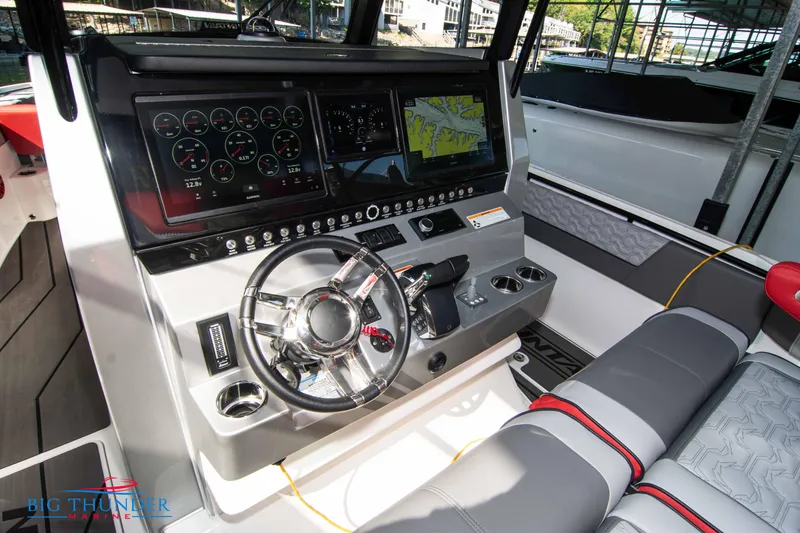Slide: The Image of The image shows the cockpit of a 2023 Fountain 32 NX boat with modern instruments and a large screen. - 34