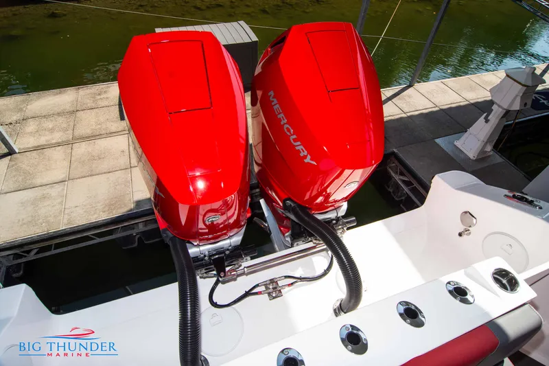 Slide: The Image of Two red Mercury outboard engines on a Fountain 32 NX boat, docked at a pier. - 14