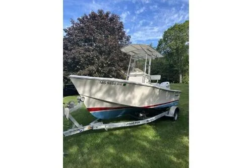 Slide: The Image of 2019 North Coast 190CC boat on trailer, parked on grass with trees in background. - 8