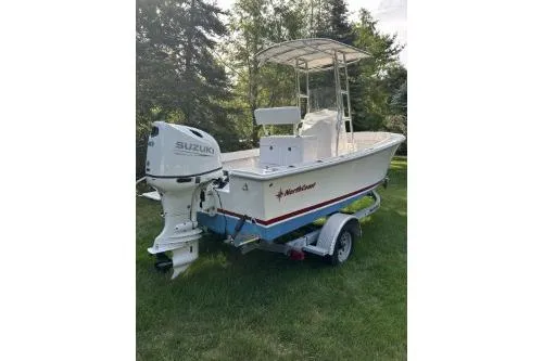 Slide: The Image of 2019 North Coast 190CC boat with Suzuki outboard motor on trailer, parked on grass. - 7