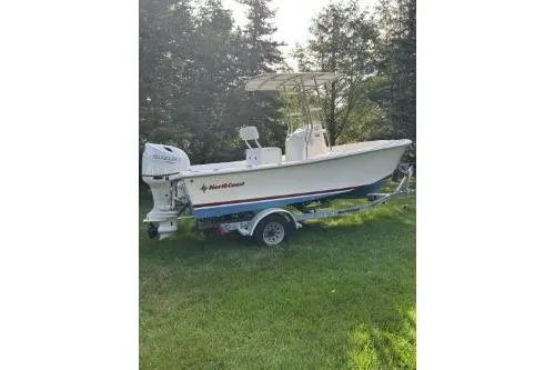The Image of 2019 North Coast 190CC boat on trailer, parked on grass with trees in background. - 0