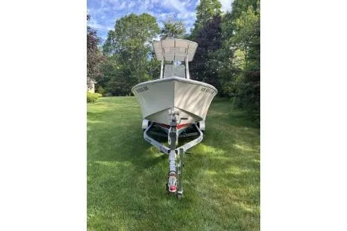Slide: The Image of 2019 North Coast 190CC boat on trailer, parked on grass with trees in background. - 10