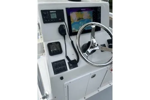 Slide: The Image of 2019 North Coast 190CC boat console with steering wheel, GPS, and control panel. - 2