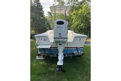 Slide: The Image of 2019 North Coast 190CC boat with outboard motor, parked on grass, surrounded by trees. - 3