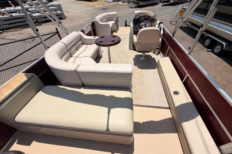 Slide: The Image of 2013 Veranda 24 pontoon boat interior with beige seating and steering console. - 8