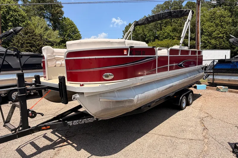 Slide: The Image of Red 2013 Veranda 24 pontoon boat on trailer, parked outdoors under clear sky. - 3