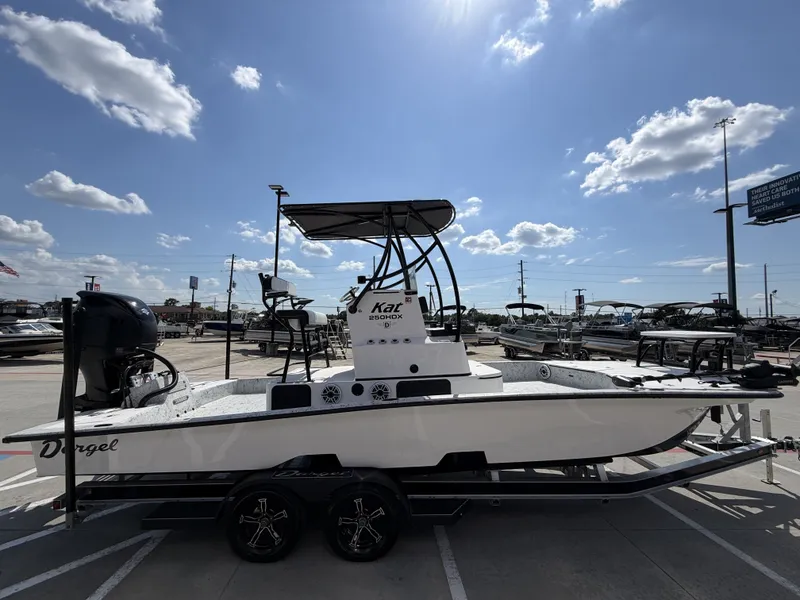 Slide: The Image of A 2026 Dargel 250 Kat HDX boat on a trailer under a sunny sky. - 8