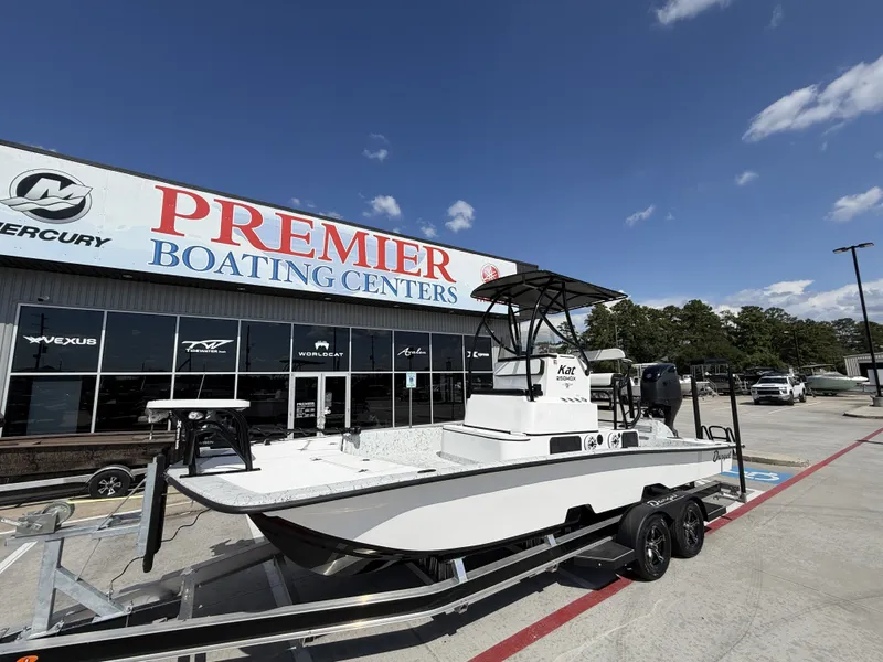 Slide: The Image of A 2026 Dargel 250 Kat HDX boat on a trailer outside a boating center. - 3