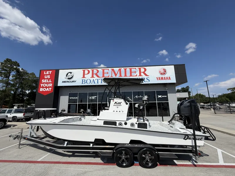 The Image of A Dargel 250 Kat HDX boat on a trailer in front of a boat dealership. - 1