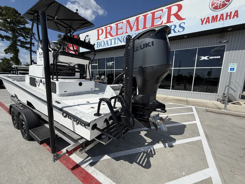 Slide: The Image of A 2026 Dargel 250 Kat HDX boat on a trailer outside a boating store. - 12