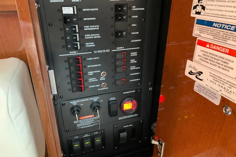 Slide: The Image of Electrical control panel of a 2011 Sea Ray Sundancer 370 boat, featuring various switches and warnings. - 45