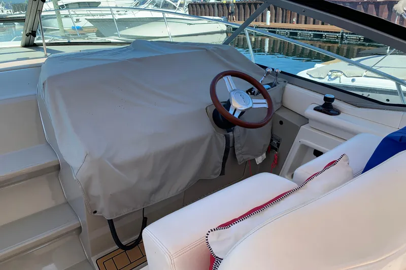 Slide: The Image of Helm of 2011 Sea Ray Sundancer 370 with covered dashboard and wooden steering wheel. - 23