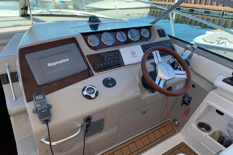 Slide: The Image of 2011 Sea Ray Sundancer 370 helm with Raymarine navigation system and wooden steering wheel. - 29