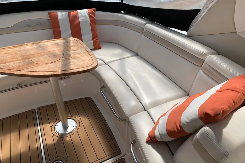 Slide: The Image of Luxurious seating area on 2011 Sea Ray Sundancer 370 with striped cushions and wooden table. - 26