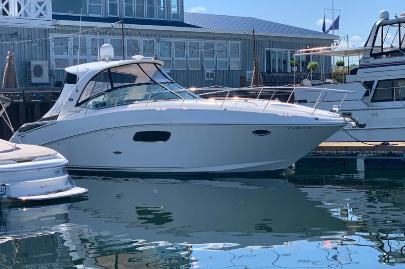Slide: The Image of 2011 Sea Ray Sundancer 370 yacht docked at marina, reflecting on calm water. - 14