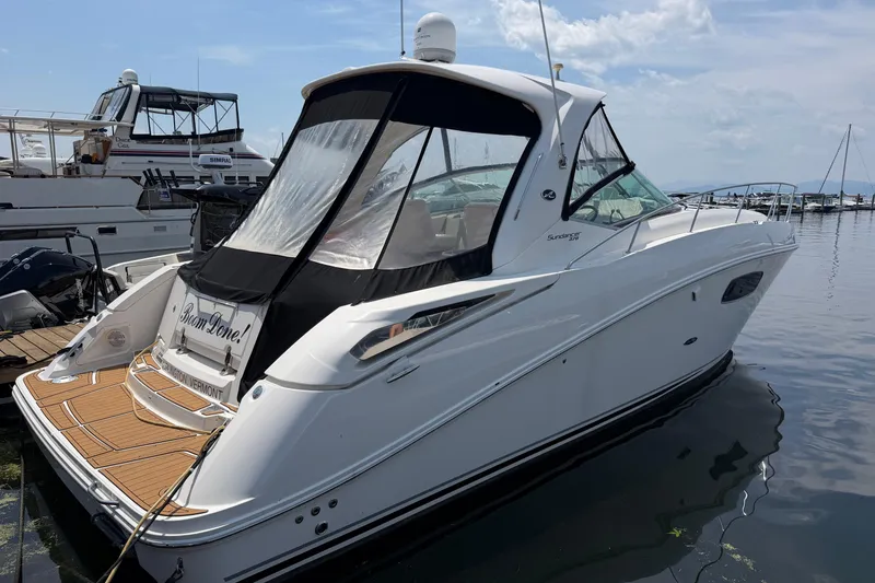 Slide: The Image of 2011 Sea Ray Sundancer 370 yacht docked at marina, featuring sleek design and spacious deck. - 2