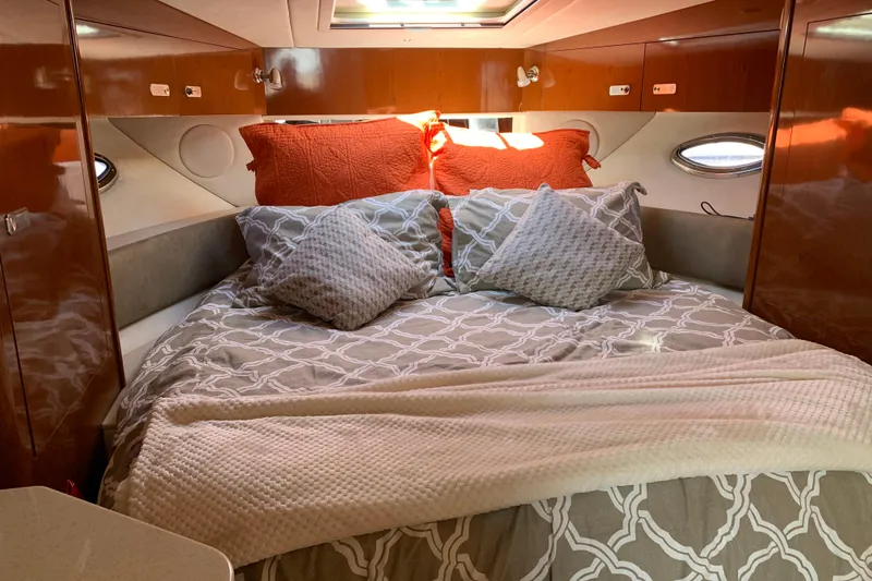 Slide: The Image of Cozy cabin interior of 2011 Sea Ray Sundancer 370 with plush bedding and wood paneling. - 40