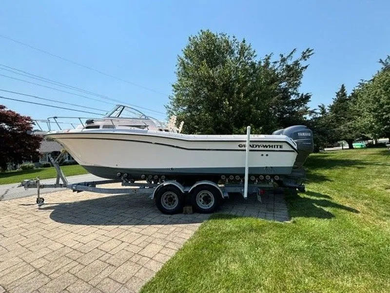 Slide: The Image of A 2007 Grady-White Journey boat on a trailer, parked on a paved path. - 2