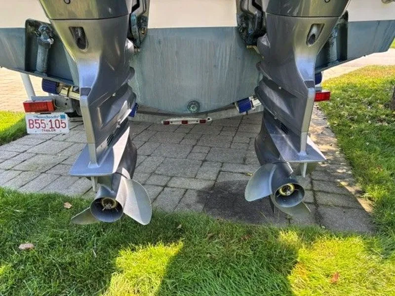 Slide: The Image of Two outboard motors with propellers are mounted on the stern of a boat on a paved area. - 20