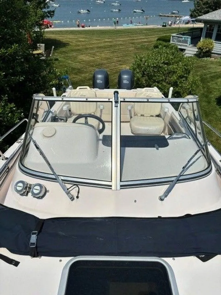 Slide: The Image of 2007 Grady-White Journey with dual outboard motors, parked by the beach, featuring a clear windshield. - 9