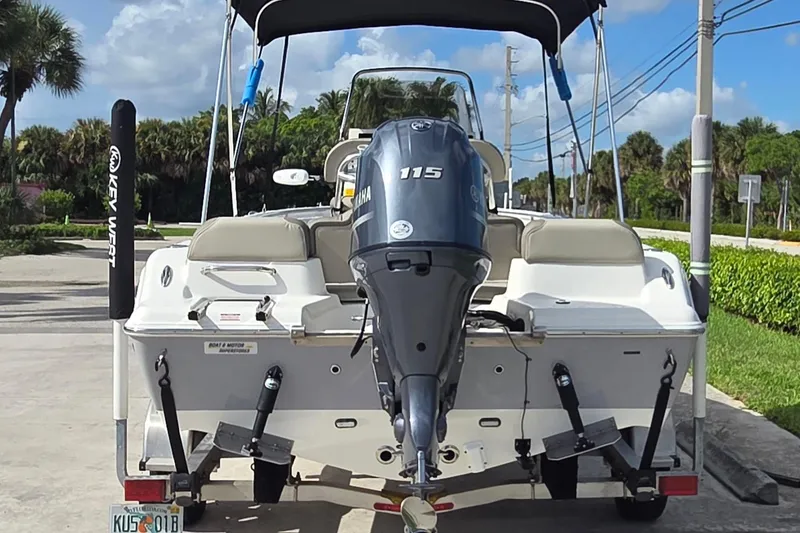 Slide: The Image of 2022 Key West 189 FS boat with Yamaha 115 engine on trailer, parked outdoors. - 2