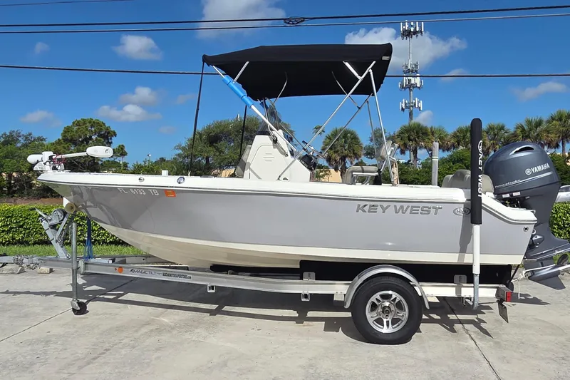 Slide: The Image of 2022 Key West 189 FS boat on trailer with Yamaha engine, parked outdoors. - 1
