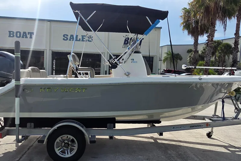 Slide: The Image of 2022 Key West 189 FS boat on trailer at dealership, featuring sleek design and canopy. - 3