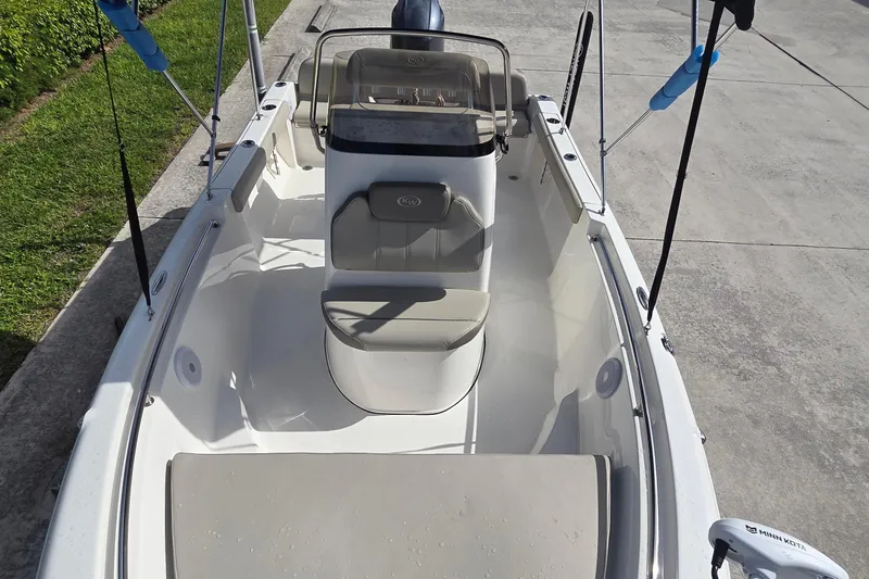 Slide: The Image of 2022 Key West 189 FS boat interior with seating and console, docked on concrete. - 9