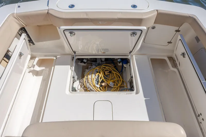 Slide: The Image of 2019 Scout 355 LXF boat storage compartment with coiled yellow hose. - 35