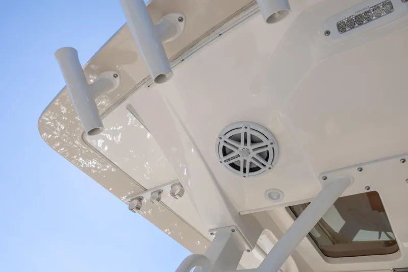 Slide: The Image of 2019 Scout 355 LXF boat ceiling with speakers and rod holders against blue sky. - 18