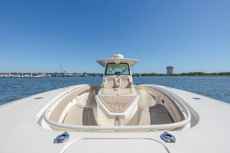 Slide: The Image of 2019 Scout 355 LXF boat on water, clear sky, luxurious seating, and sleek design. - 32