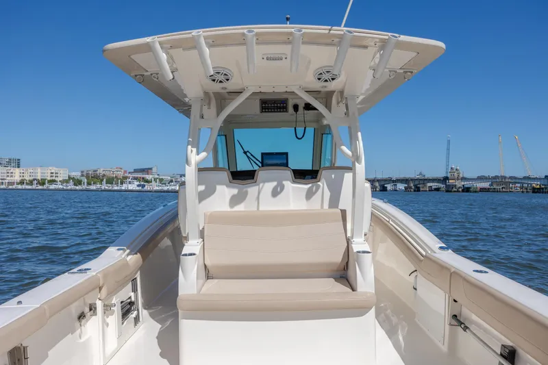 Slide: The Image of 2019 Scout 355 LXF boat on water, featuring spacious seating and modern helm. - 14