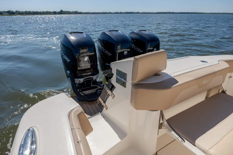Slide: The Image of 2019 Scout 355 LXF boat with triple Mercury engines on a sunny day. - 11