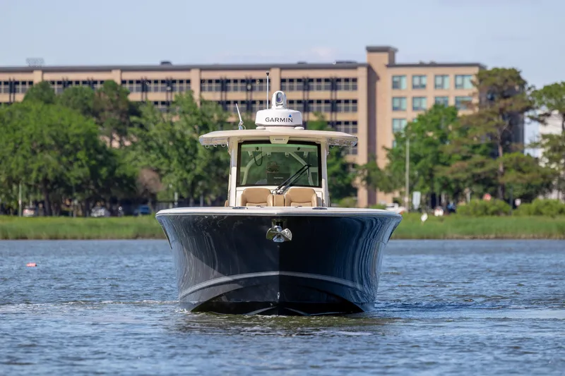 Slide: The Image of 2019 Scout 355 LXF boat on water with buildings in background. - 8