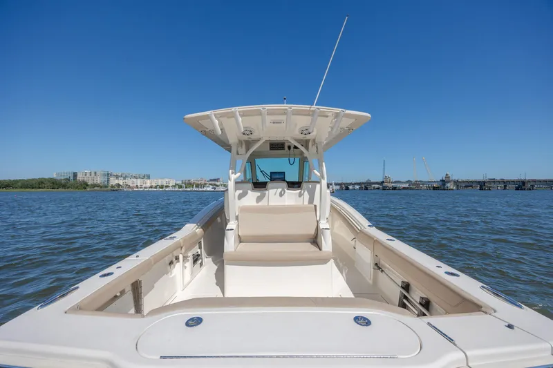 Slide: The Image of 2019 Scout 355 LXF boat on calm water with clear blue sky. - 13