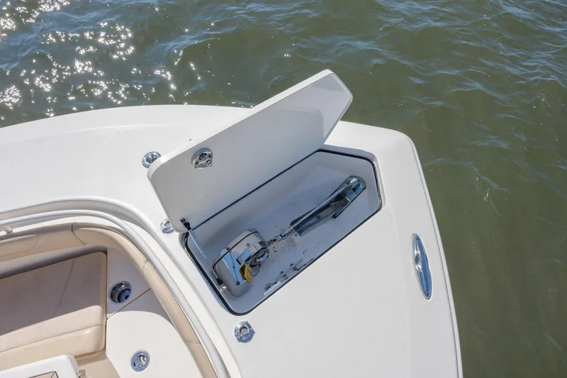 Slide: The Image of 2019 Scout 355 LXF boat anchor compartment open on calm water. - 31