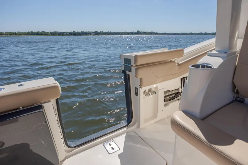 Slide: The Image of 2019 Scout 355 LXF boat interior with open side door, overlooking calm water. - 17