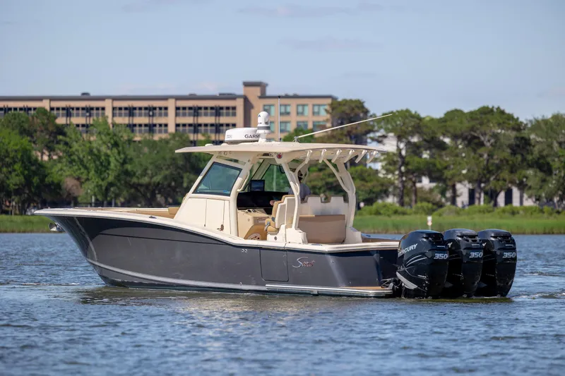Slide: The Image of 2019 Scout 355 LXF boat with triple Mercury engines on a calm waterway. - 4