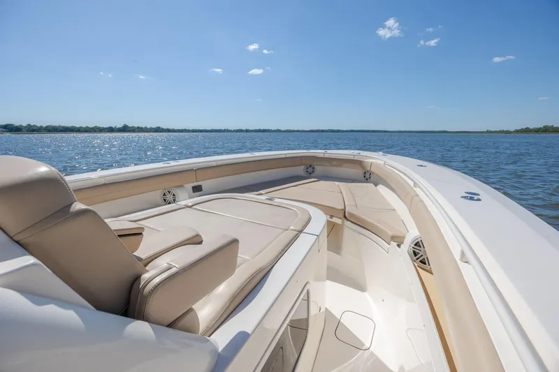 Slide: The Image of 2019 Scout 355 LXF boat interior with luxurious seating on a sunny day. - 28