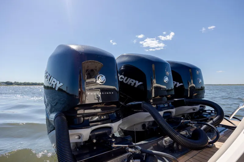 Slide: The Image of 2019 Scout 355 LXF boat with triple Mercury outboard engines on open water. - 12